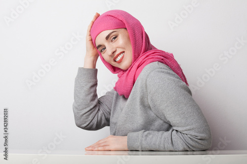 Portrait of a muslim woman wearing a head scarf hijab and smilling. Isolated.