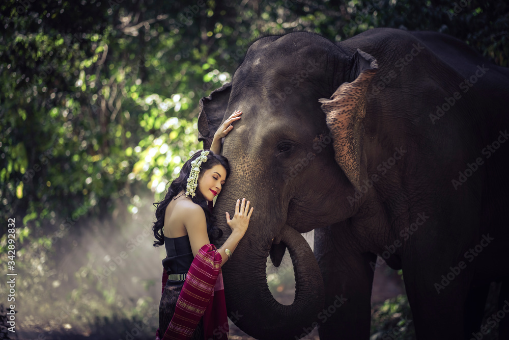 Fototapeta premium Beautiful woman wear traditional Thai dress with elephant.