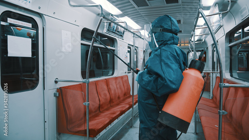 Cleaning and Disinfection at train , coronavirus epidemic. Infection prevention and control of epidemic. Man working with protective suit, face shield and maska.