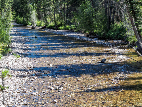 Clear water of mountain stream falling over river stones.