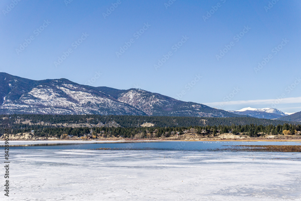 beautiful columbia lake with ice blue sky rocky mountains landscape british columbia canada.