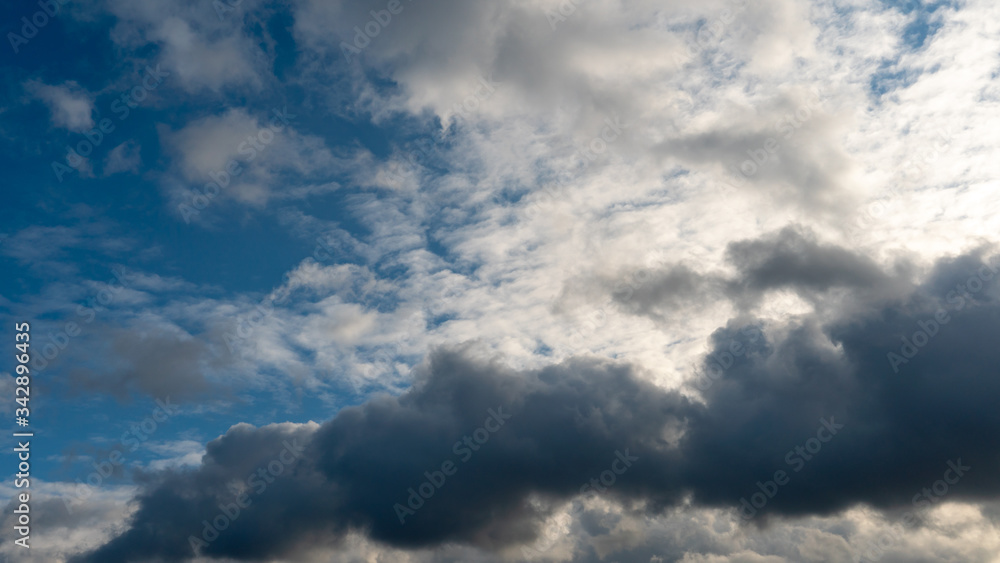 A cluster of light and fluffy clouds interspersed with dark gray clouds. Before the rain and the thunderstorm. A cluster of light and fluffy clouds interspersed with dark gray clouds. Before the rain and the thunderstorm.