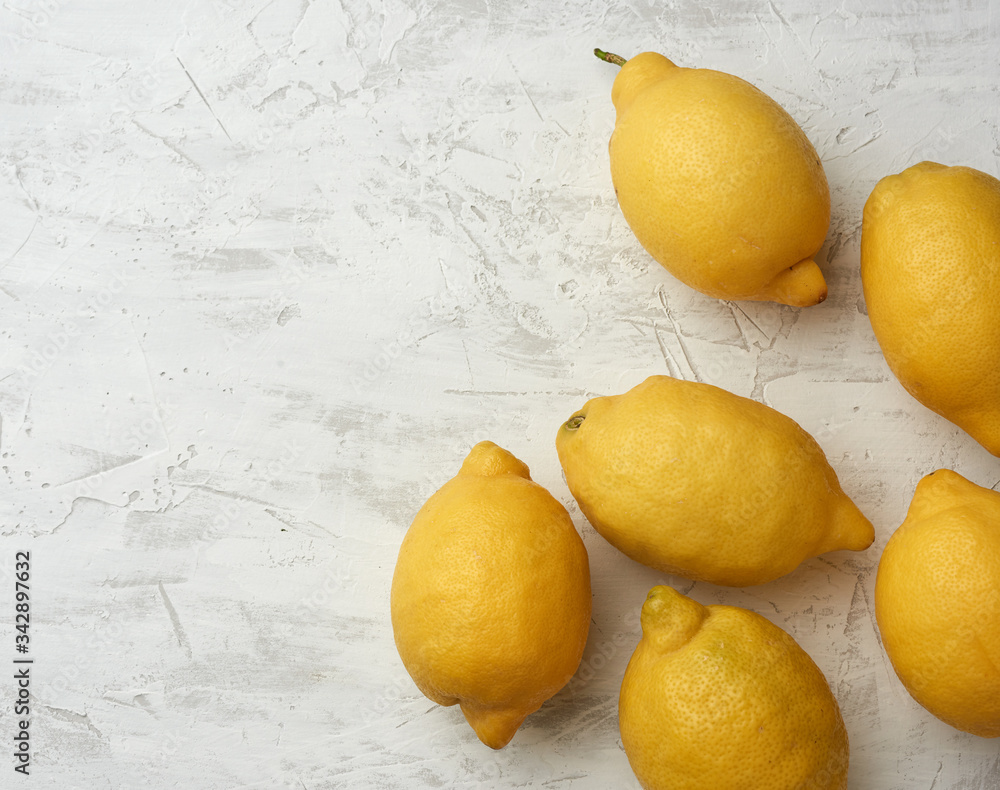 ripe yellow lemons on a gray table, ingredient for lemonade