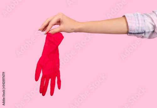 Female hand holding a pink rubber glove