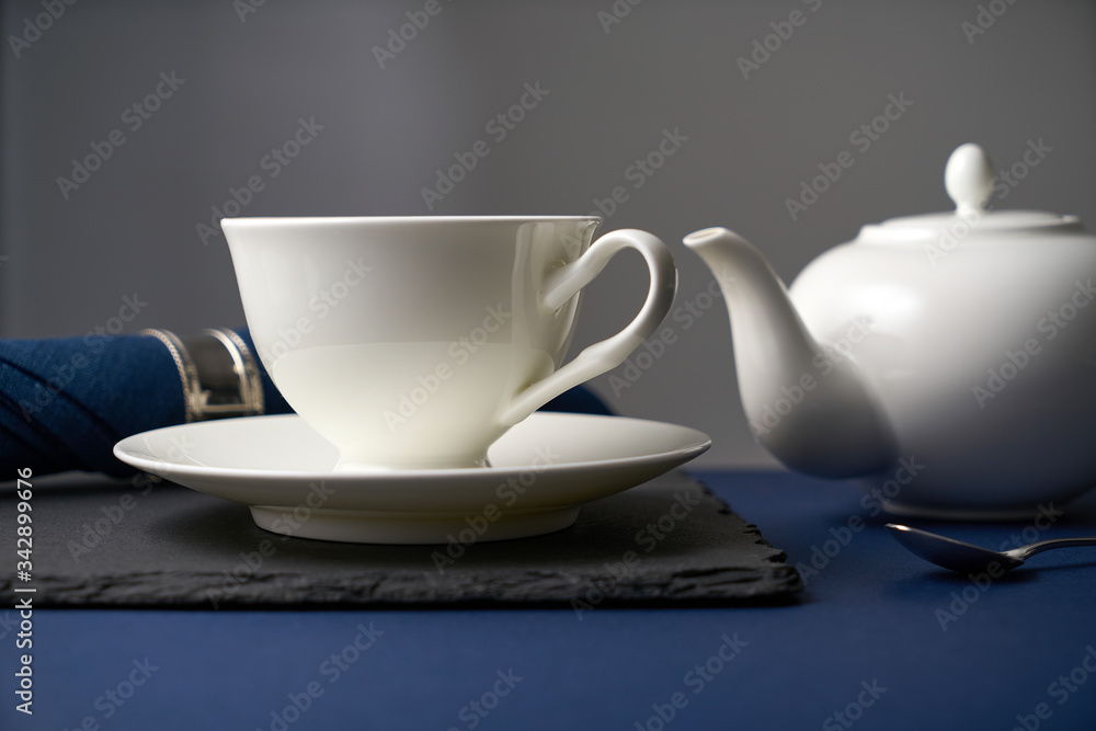 Tea set from a white ceramic teapot and a white cup