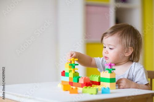 baby plays in the constructor. small child builds a castle out of blocks. concept of development of fine motor skills