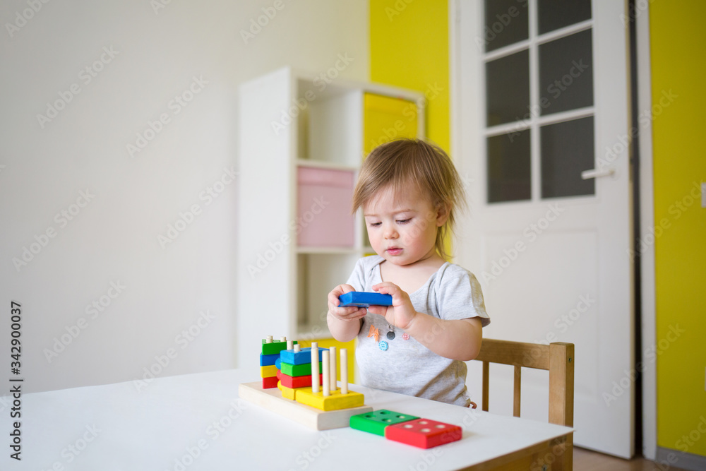 baby plays in the constructor. small child puts the rings on the pins. concept of development of fine motor skills baby plays in the constructor. small child puts the rings on the pins. concept of development of fine motor skills