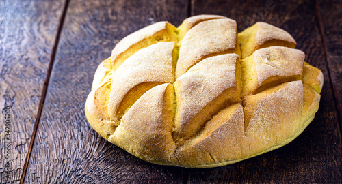 homemade corn bread made in brazil, organic and without preservatives. natural product, rustic wood background. photo