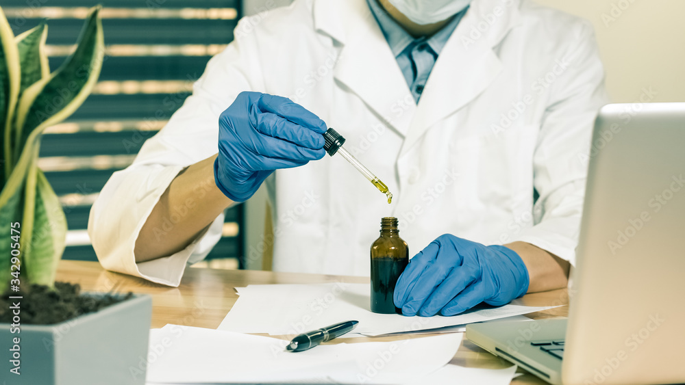 Examining cannabis cbd oil in medical scientist hands in pharmaceutical laboratory with mask and gloves. 4k resolution Examining cannabis cbd oil in medical scientist hands in pharmaceutical laboratory with mask and gloves. 4k resolution