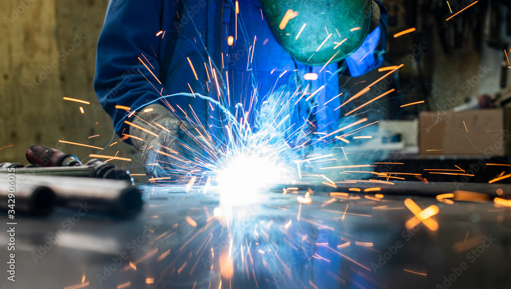 Welder in his workshop welding metal Welder in his workshop welding metal