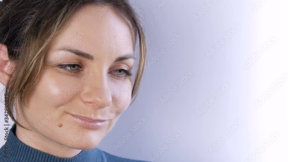 Portrait of a beautiful happy feminine young woman or girl with blond hair and green eyes looking seriously and thoughtfully to the side and smiling tenderly at the camera on a white background Portrait of a beautiful happy feminine young woman or girl with blond hair and green eyes looking seriously and thoughtfully to the side and smiling tenderly at the camera on a white background