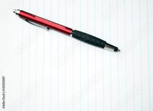 An ink pen and notebook paper is ready for note taking or journaling. Bokeh effect.