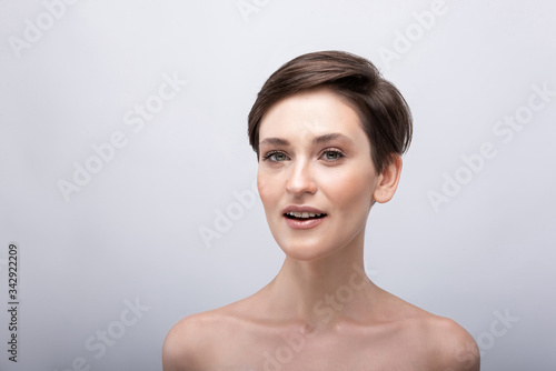 Portrait of a young girl with a long neck  almost no makeup on her face  photo without retouching  natural makeup and vivid emotions  smile and joy in the look