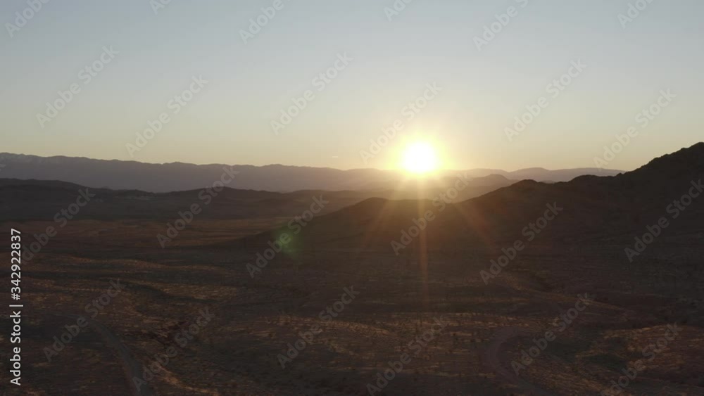 An aerial tracking shot of the sun setting behind the Avawatz Mountains as see from the South Nopah Range in Tecopa, Ca. Drone take off, landing and operation conducted outside of wilderness boundary. An aerial tracking shot of the sun setting behind the Avawatz Mountains as see from the South Nopah Range in Tecopa, Ca. Drone take off, landing and operation conducted outside of wilderness boundary.