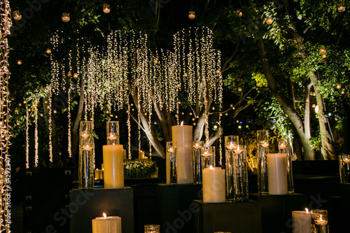 Decoración para boda, salón de eventos. Con velas y series de luz artificial con plantas photo