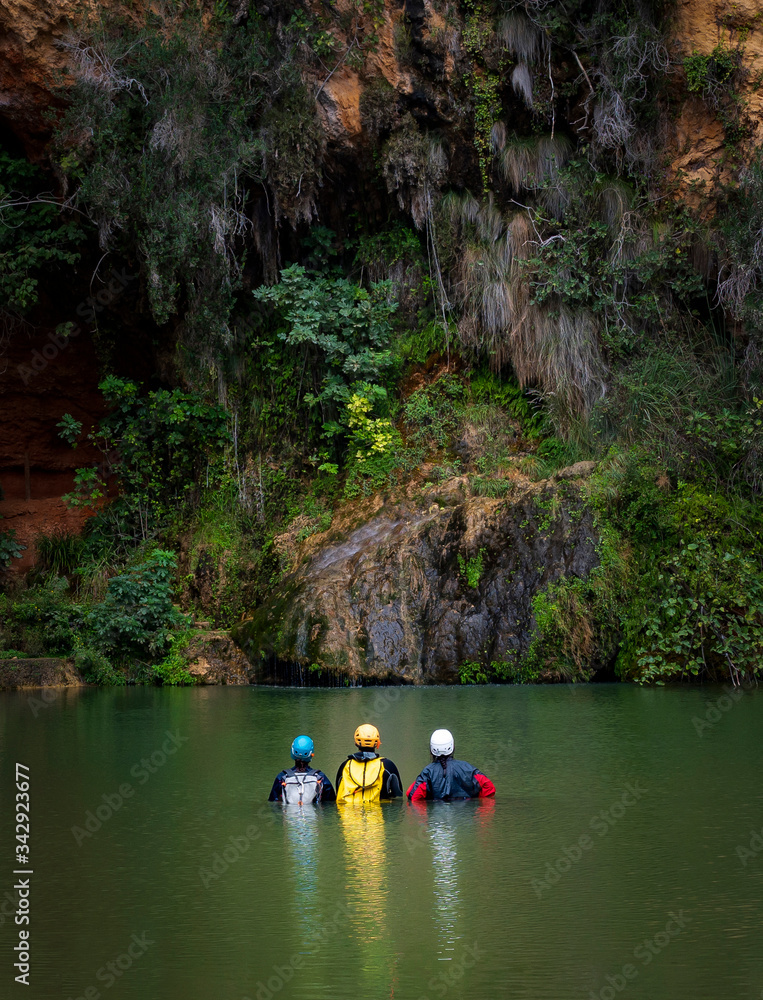 grupo de hombres aventureros espeleólogos metidos en el agua mirando el descenso del barranco grupo de hombres aventureros espeleólogos metidos en el agua mirando el descenso del barranco