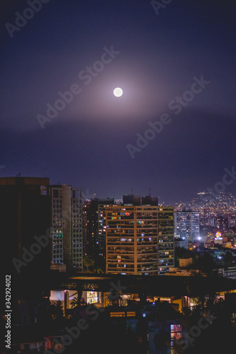 Full moon over Santiago skyline with blue sky night, Chile
