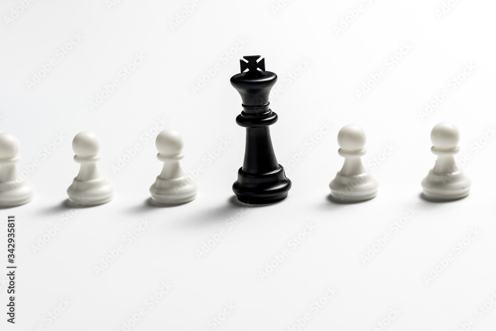 chess king is standing against white pawns. Symbol of leadership and confrontation. Horizontal frame chess king is standing against white pawns. Symbol of leadership and confrontation. Horizontal frame