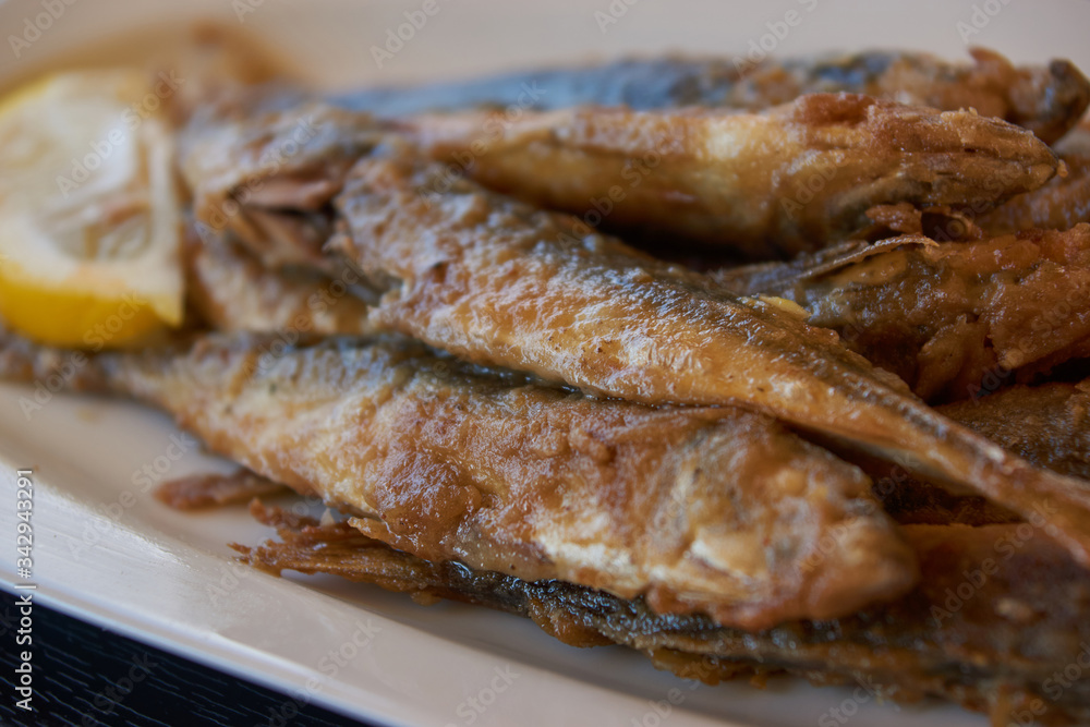 Fried smelt on a plate. Fish dish in a cafe. Seaside lunch