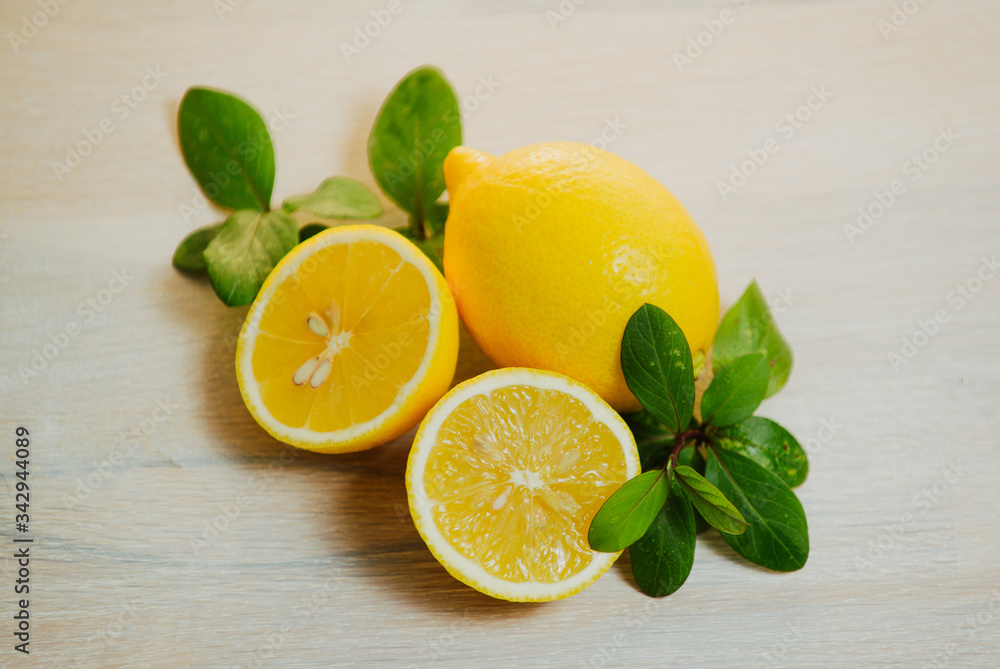 Ripe yelliw lemon citrus and mint leaves on wooden dest Ripe yelliw lemon citrus and mint leaves on wooden dest