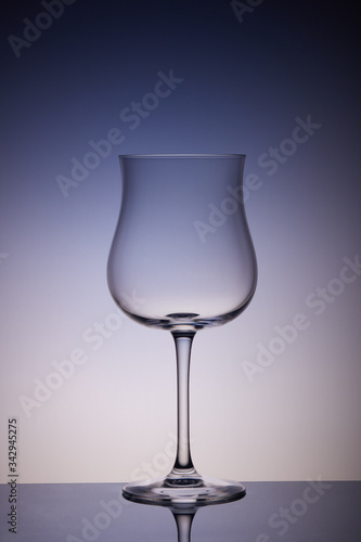 Empty glass for wine on multicolor gradient background. Wineglass