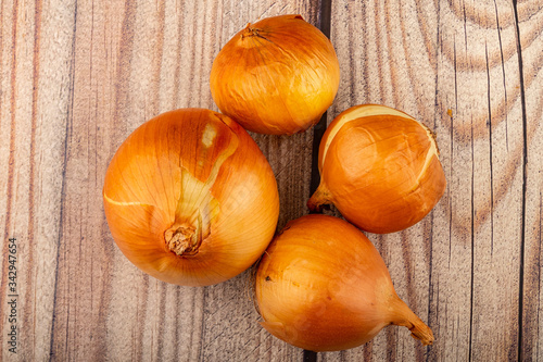 Juicy ripe onions on a wooden background. Close up.