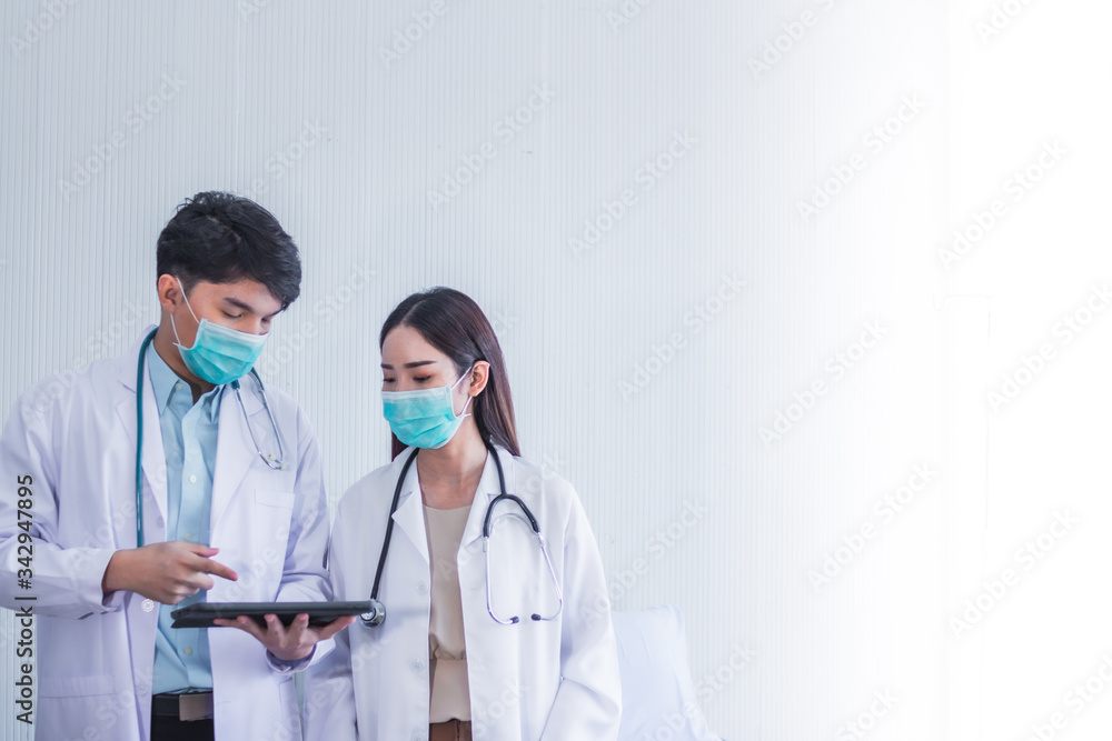 asian man and woman doctor wearing white gown uniform hygenic mask pointing to tablet and clipboard coronavirus covid19 scourge asian man and woman doctor wearing white gown uniform hygenic mask pointing to tablet and clipboard coronavirus covid19 scourge