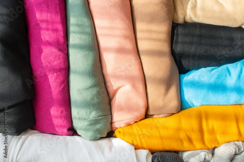 Close up of a group of colorful T-Shirt pack and arranging in suitcase, prepare for travel. A T-shirt is a style of fabric shirt made of a stretchy, light and inexpensive fabric and are easy to clean.