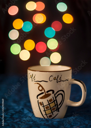 cup of coffee with colored bokeh lights in background