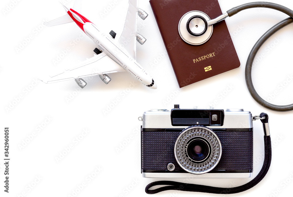 Mockup image of medical stethoscope, passport book, airplane model, camera isolated on white background. Business trip and travel, leisure time, immigration concept. Top view. Flat lay.