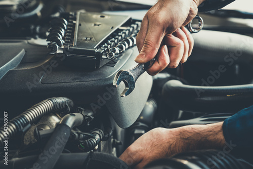 Foto Professional mechanic providing car repair and maintenance service in auto garage