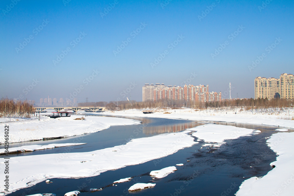 Frozen river covered by snow landscape in a city 