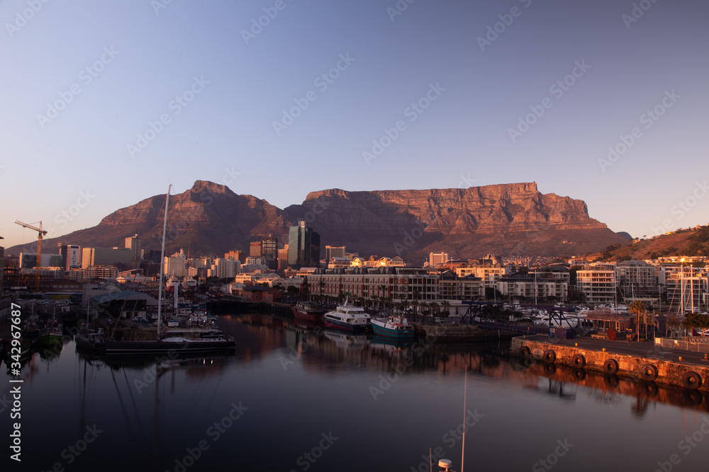 Golden Hour at the Harbor: Sunrise view of the Table Mountain from waterfront of Cape Town
