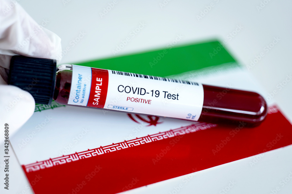 Obraz premium Testing for presence of coronavirus. Tube containing a blood sample that has tested positive for COVID-19. Flag of Iran in the background.