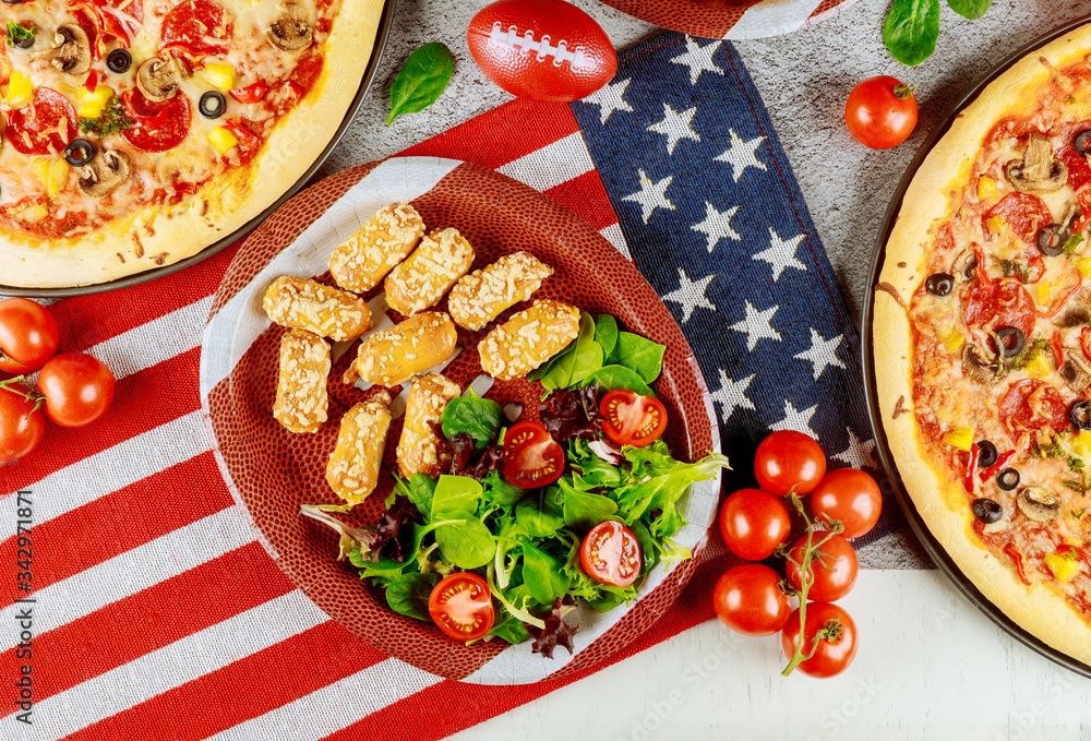 Festive party table with fried potato, pizza and vegetable for American holiday.