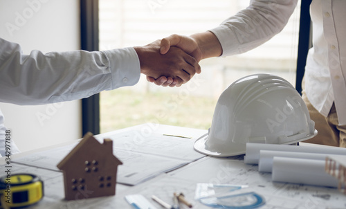 Partnership engineering man with construction worker greeting shaking hand a foreman at renovating apartment.