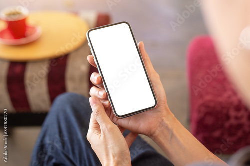 cell phone Mockup image blank white screen.woman hand holding texting using mobile on desk at coffee shop.background empty space for advertise text.people contact marketing business,technology