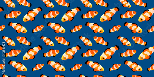 seamless pattern with bright clown fishes on dark blue background