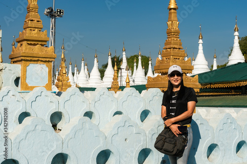 Adult Asian tourist visits white pagodas and golden temple in Sandamuni, Myanmar photo