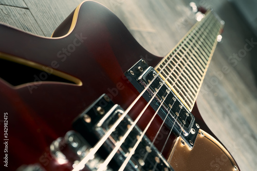 Red retro semi hollow electric guitar on a grey wooden floor photo