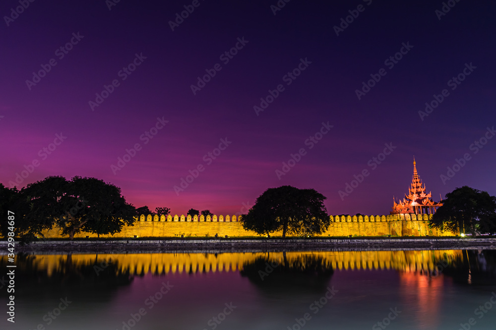 Dramatic night scene of most famous Royal Palace wall and trees reflect on water at Mandalay,Myanmar