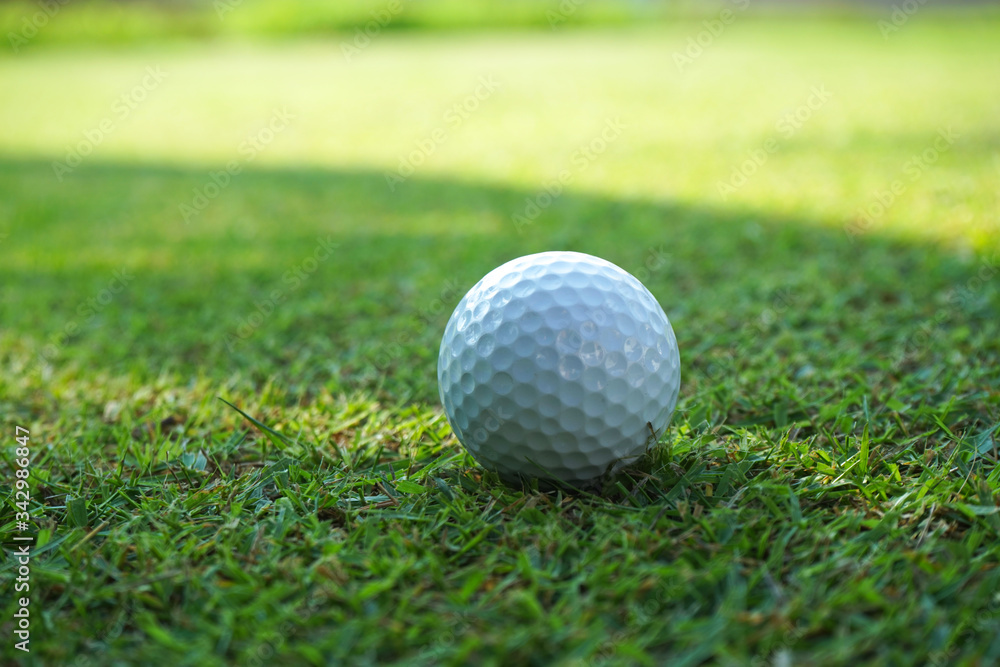 Golf ball on green grass sunset background Golf ball on green grass sunset background