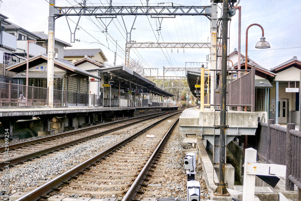 Perspective and outside view of Metal railroad track at Nara train platform on blue sky background.