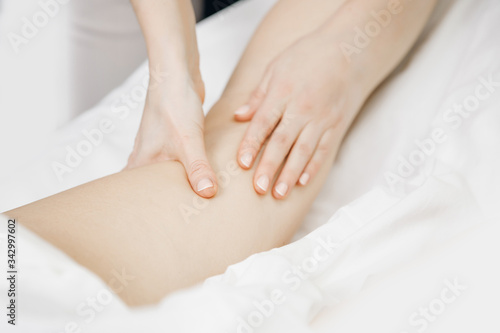 Anti-cellulite massage treatment on legs of young women beauty spa