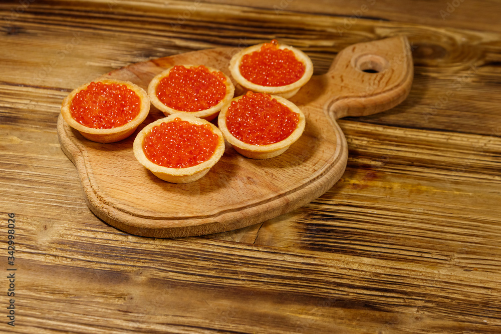 Tartlets with red caviar on a wooden table Tartlets with red caviar on a wooden table