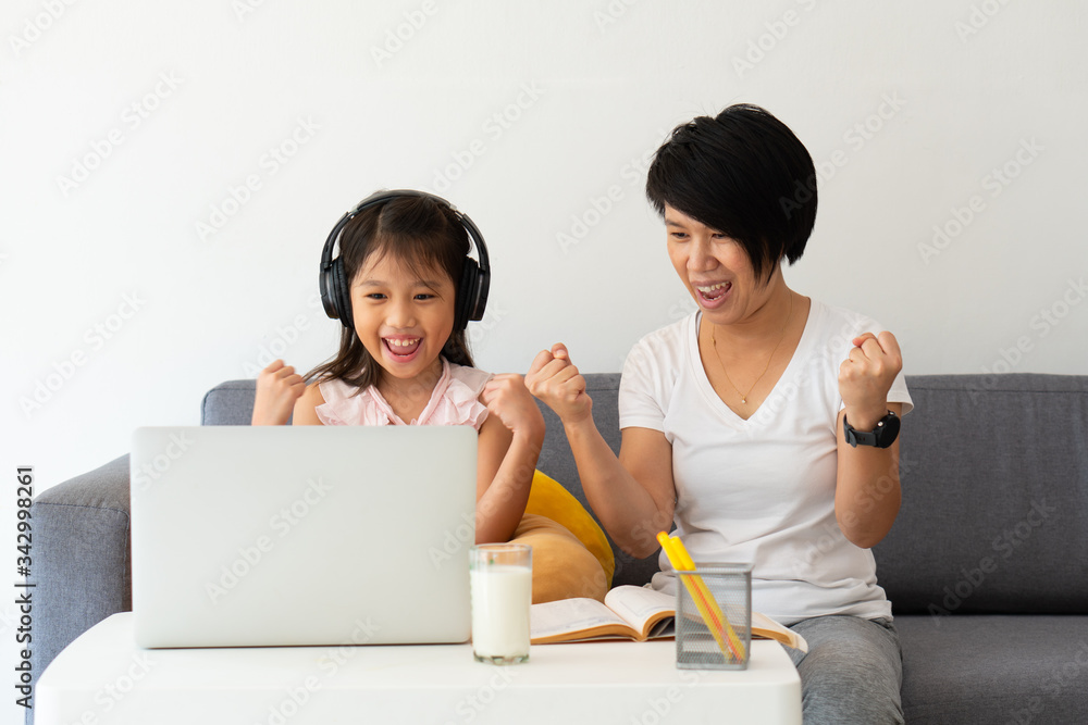 An asian mother is teaching a young daughter from the online computer lesson as the home school education because of covid-19 or coronavirus outbreak An asian mother is teaching a young daughter from the online computer lesson as the home school education because of covid-19 or coronavirus outbreak