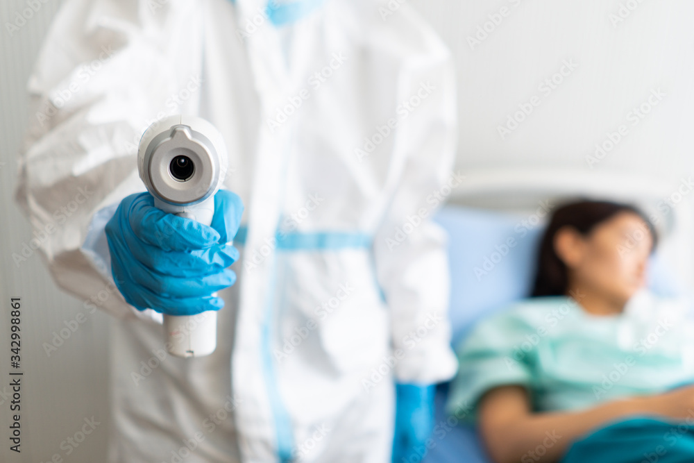 two doctor in personal pretective equipment or ppe treating the asian woman patient with covid-19 or coronavirus infection in the isolation unit in the hospital during pandemic. medical concept two doctor in personal pretective equipment or ppe treating the asian woman patient with covid-19 or coronavirus infection in the isolation unit in the hospital during pandemic. medical concept