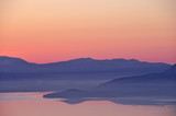 夜明けの湖、山並みのシルエット。屈斜路湖、北海道、日本。
