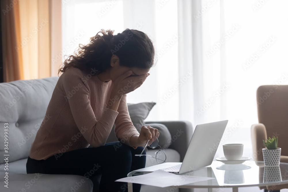Exhausted young woman dropping off eyeglasses, suffering from dry eyes syndrome, side view. Stressed female freelance worker feeling tired, overwhelmed by huge amount of computer work at home. Exhausted young woman dropping off eyeglasses, suffering from dry eyes syndrome, side view. Stressed female freelance worker feeling tired, overwhelmed by huge amount of computer work at home.