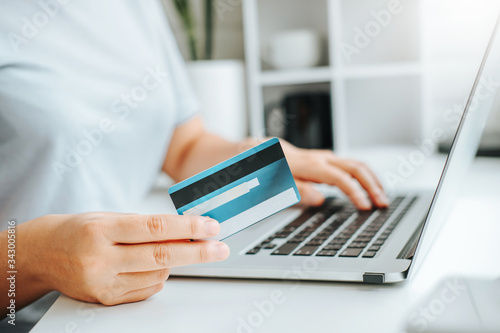 Asian young woman resting and browsing internet with Laptop holding credit card online shopping concept